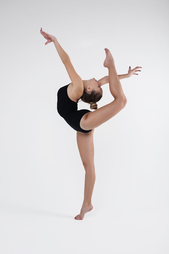 A skilled ballet dancer demonstrating flexibility and strength in a studio setting.