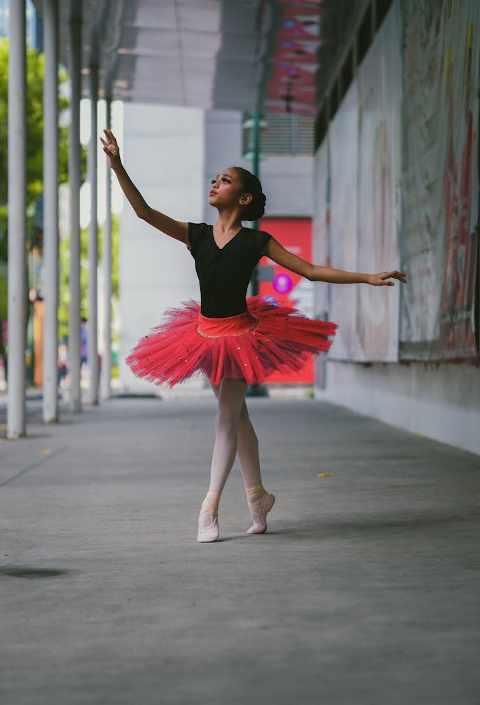A graceful ballet dancer performs outdoors in a vibrant tutu, showcasing elegance and poise.